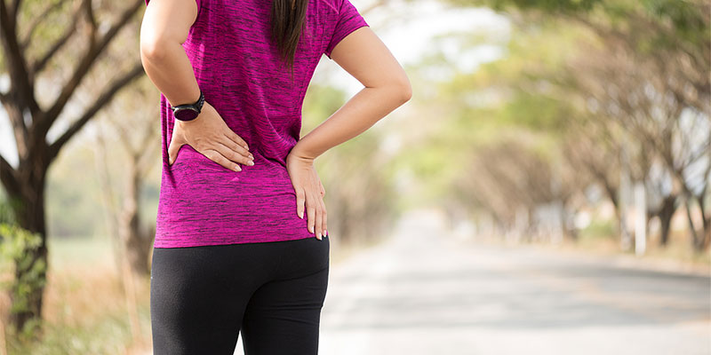 Woman outdoors holding her hip with hip pain in Gresham OR